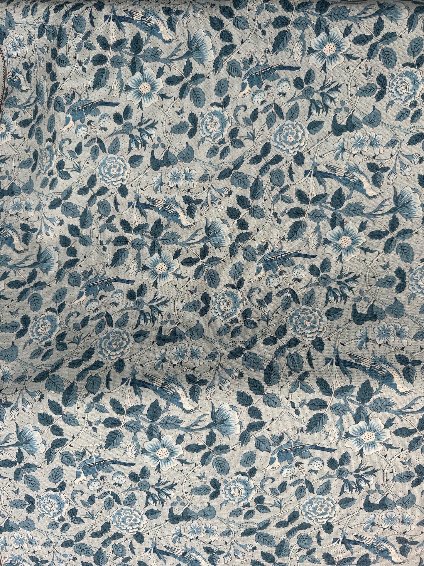 Floral patterned fabric with blue and green colors on a light blue background