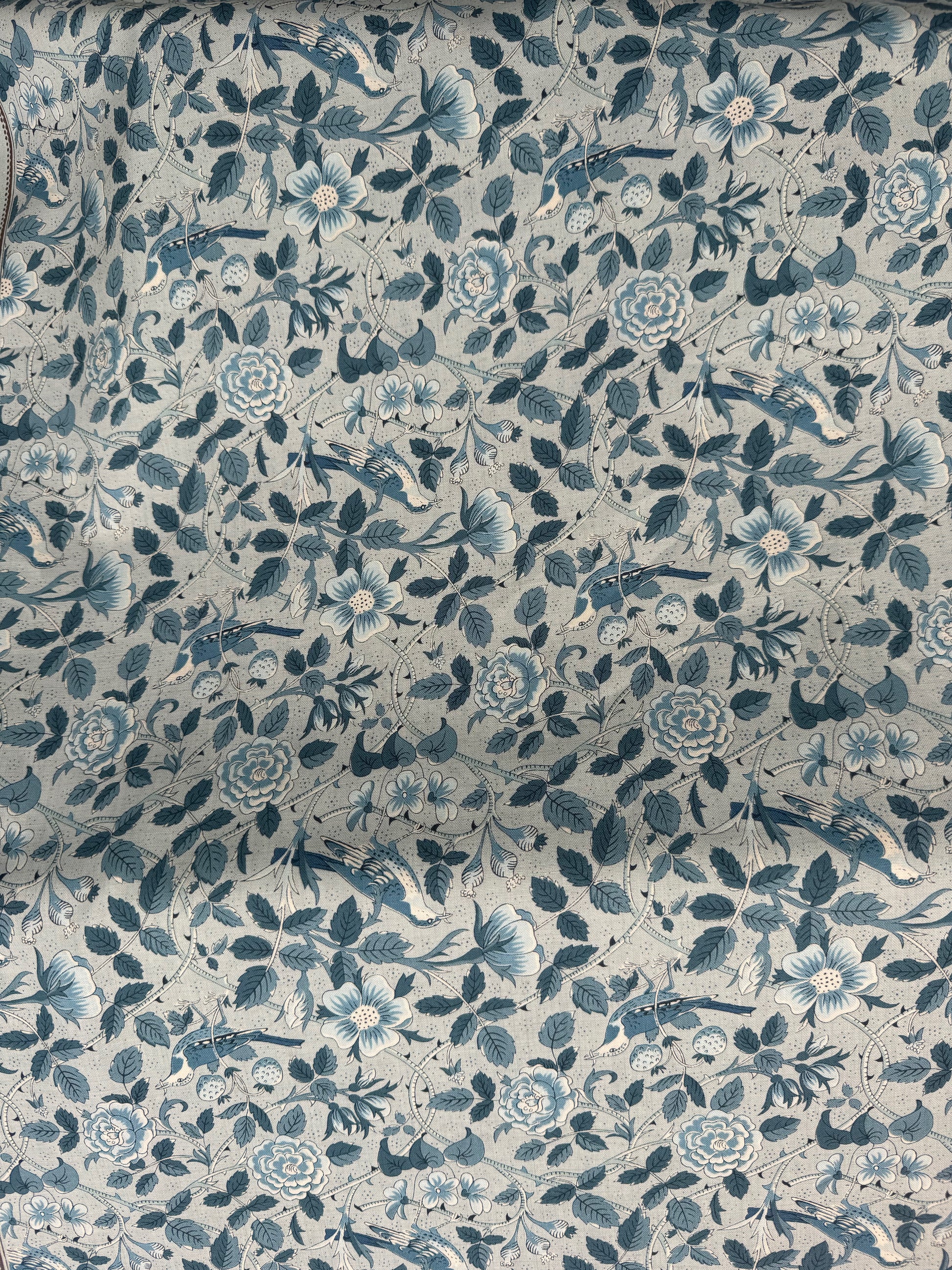 Floral patterned fabric with blue and green colors on a light blue background