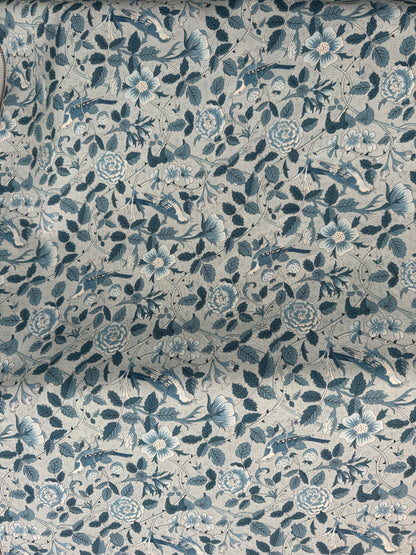Floral patterned fabric with blue and green colors on a light blue background