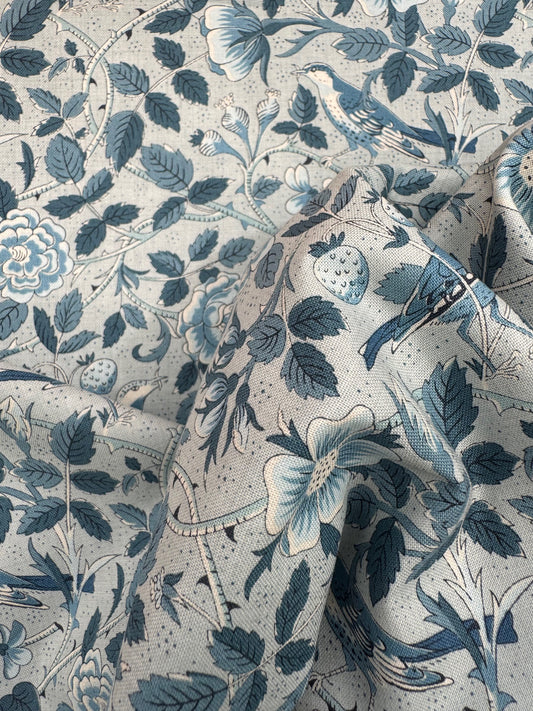 Close-up of a fabric with blue floral and leaf pattern on a light blue background