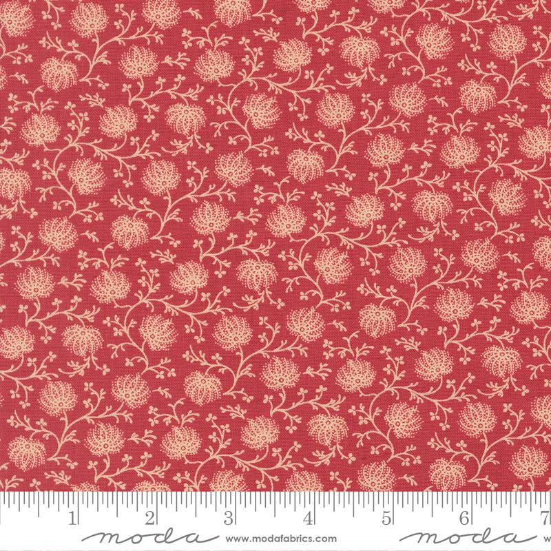Floral patterned fabric with a ruler at the bottom for scale, on a red background.