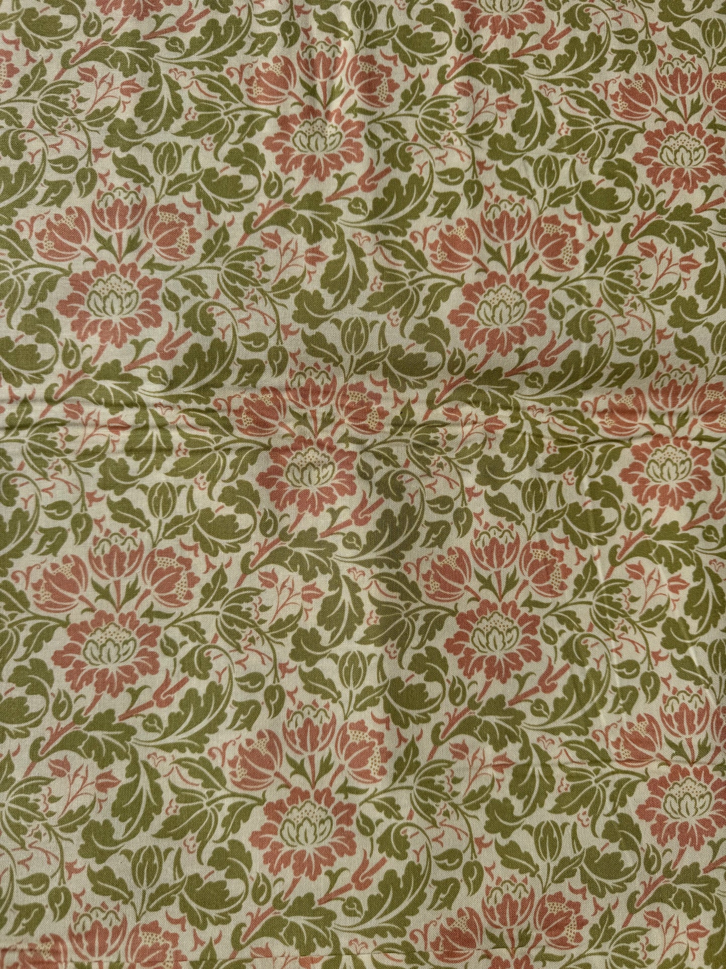 Floral patterned fabric with red and green flowers on a beige background