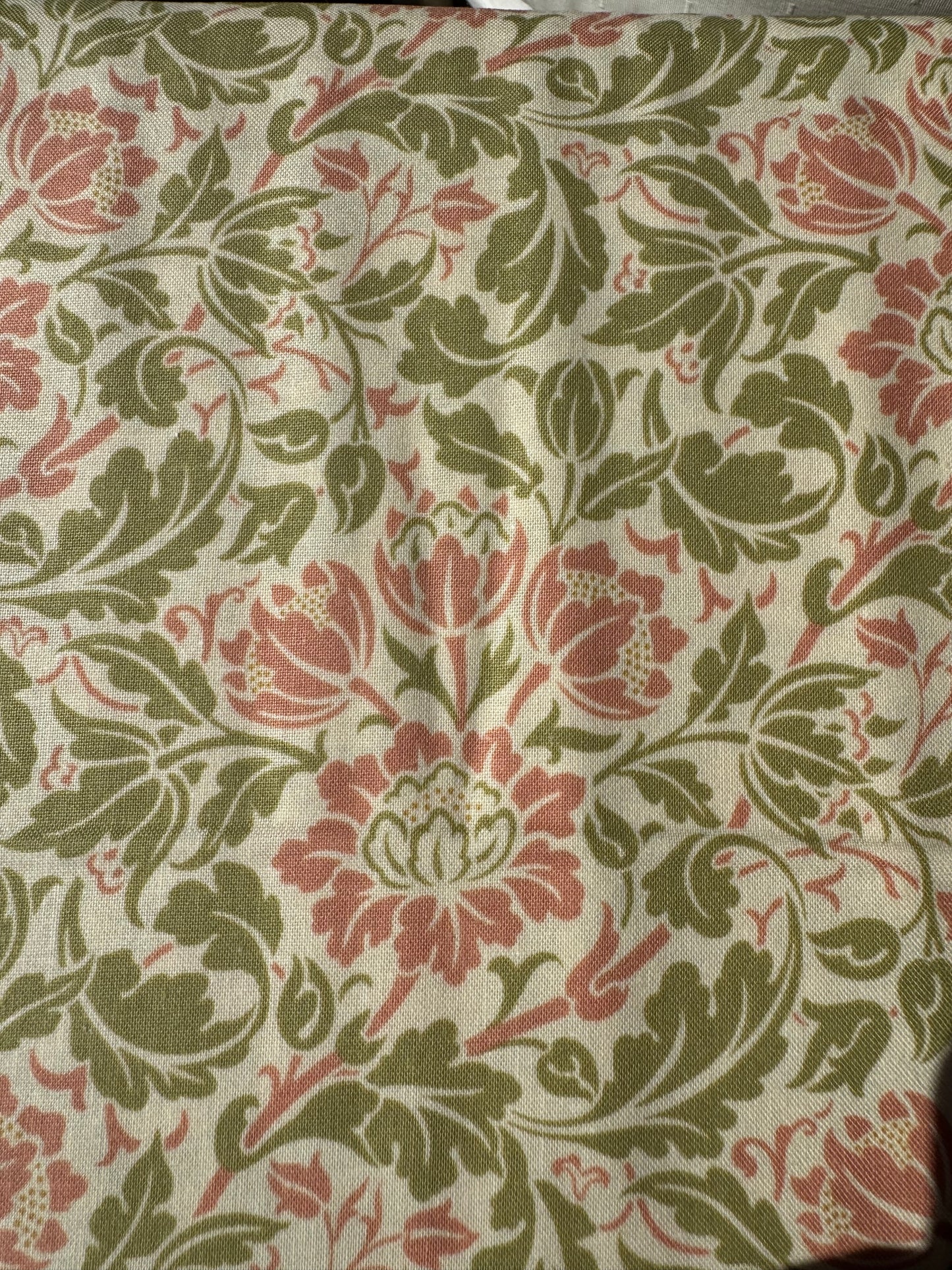 Fabric with a floral pattern featuring red and green colors.