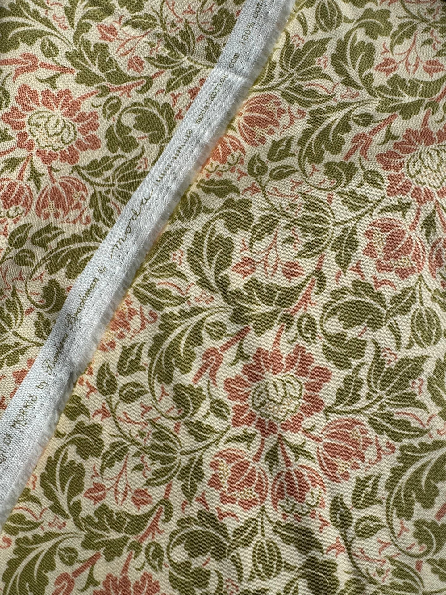 Floral fabric pattern with red and green colors on a beige background