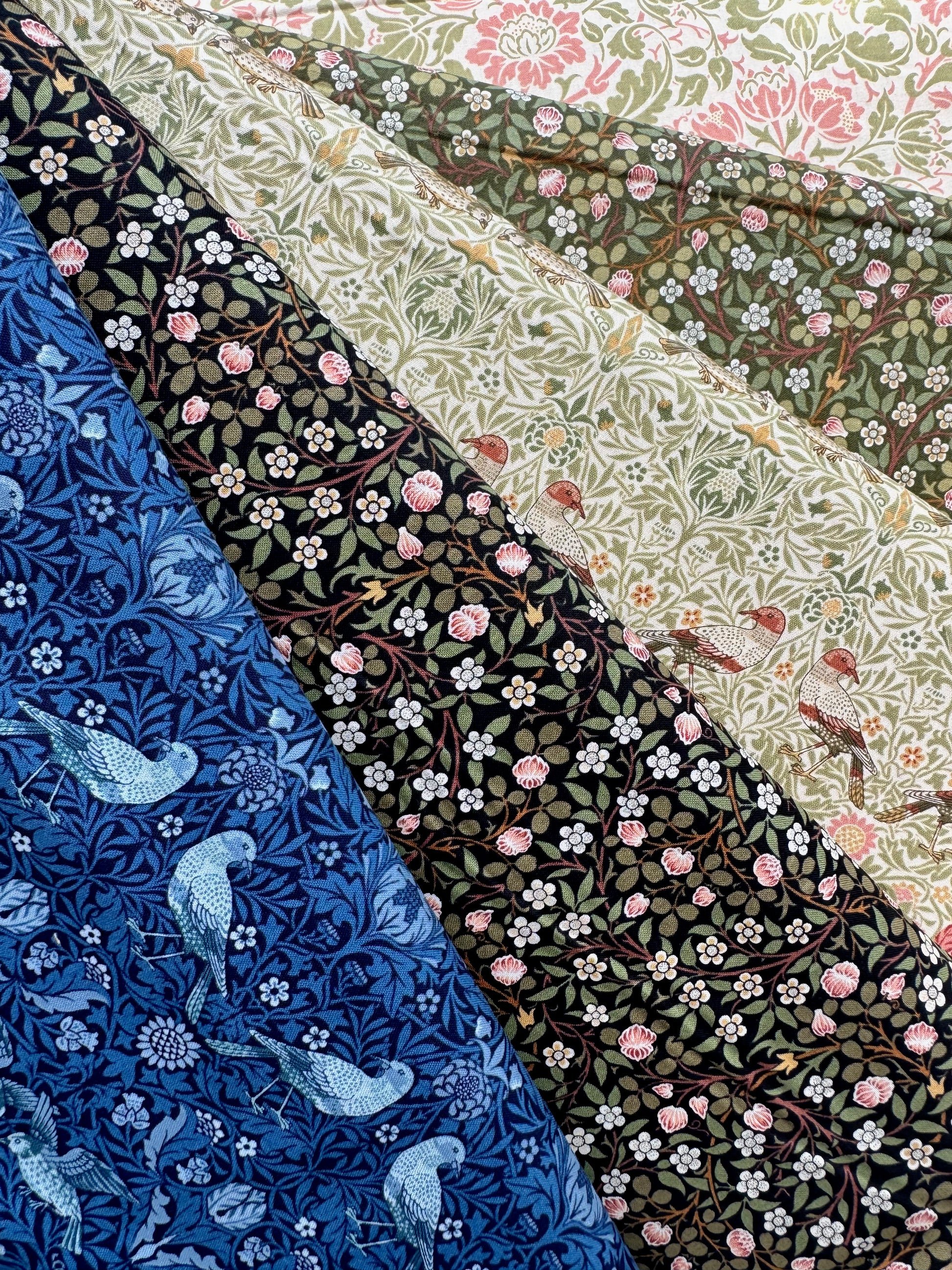 Collection of floral and nature-themed fabric swatches in various colors for the Morris Muse collection by Barbara Brackman for Moda.